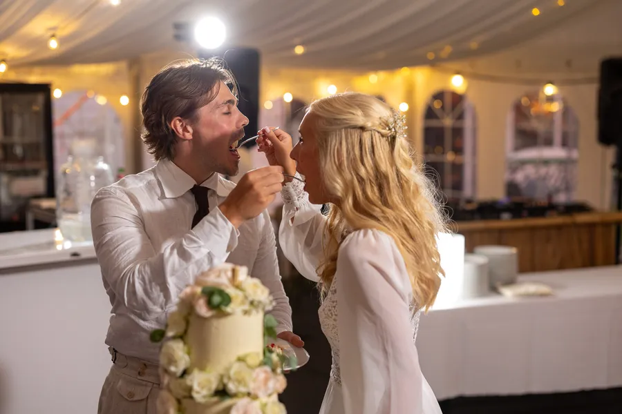 Carl og Tonje fôrer hverandre kake — leken stund under bryllupsmiddagen