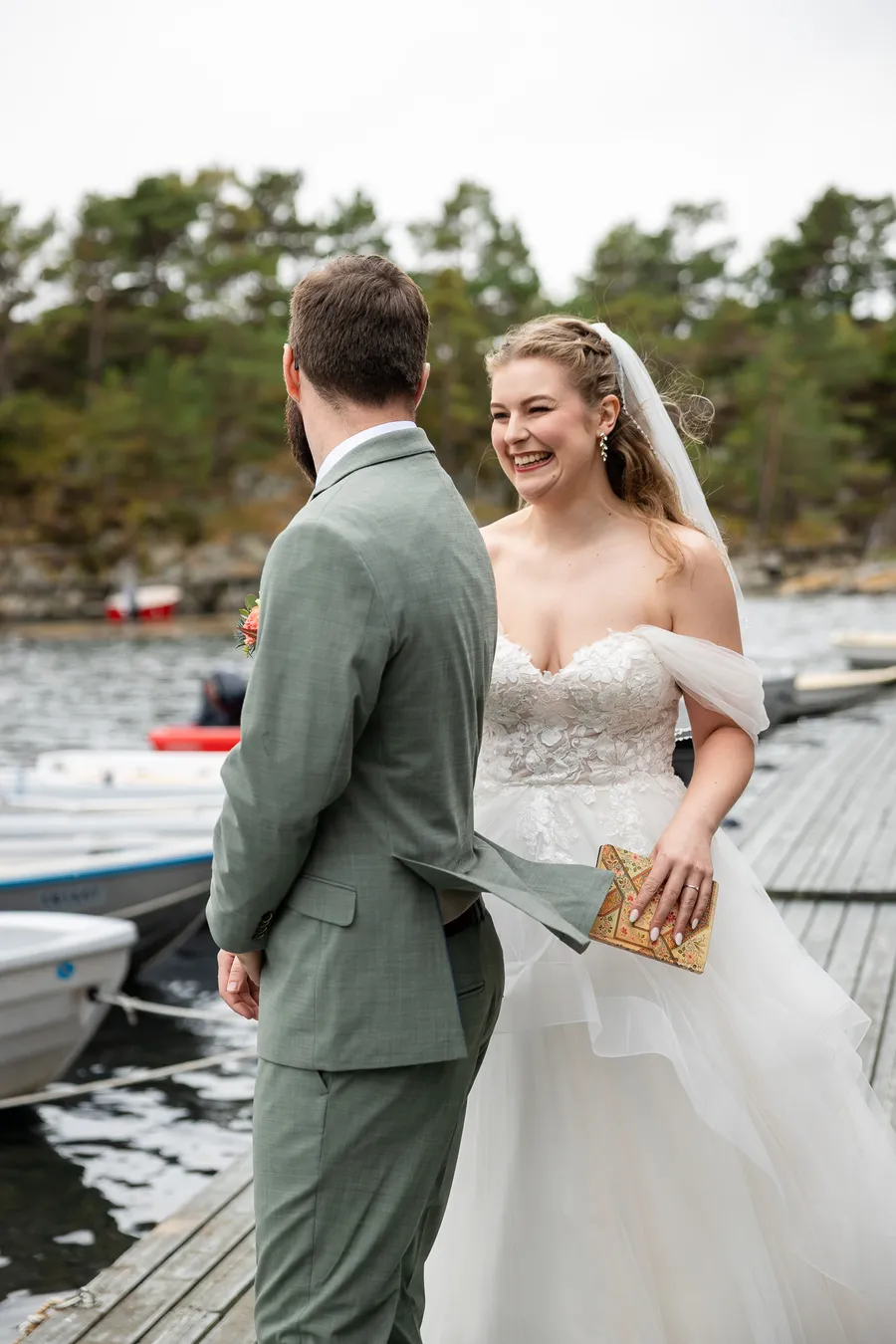Brud ler høyt under first look på brygge ved Tromøy bryllup