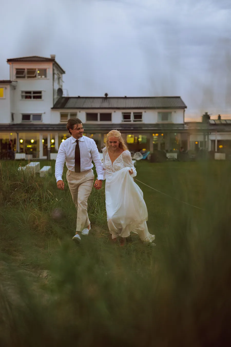 Tonje og Carl forlater hotellet på vei mot stranden i blå time