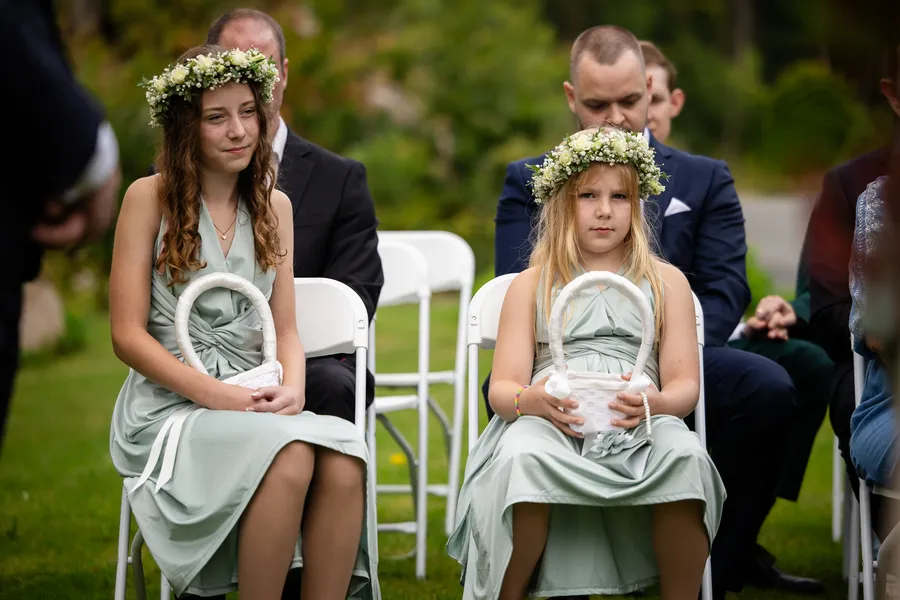 To brudepiker med blomsterkranser i salviegrønne kjoler på seremoni