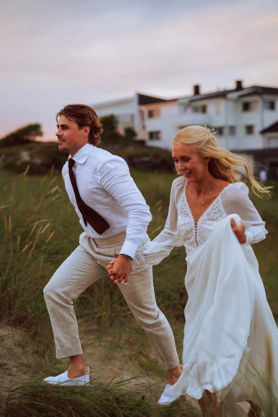 Brudepar i strandgress under sommernatt