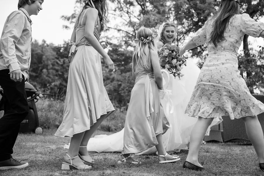 Barn danser rundt bruden i hagen, sortvitt, fest etter vielse på Tromøy