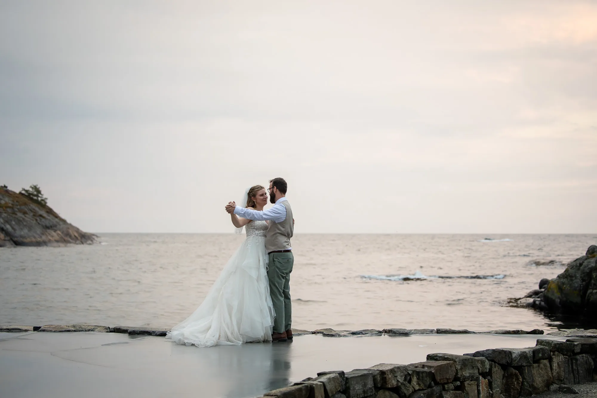 Turid og Erik danser ved sjøkanten på Tromøy ved solnedgang — bryllupsfotograf Arendal